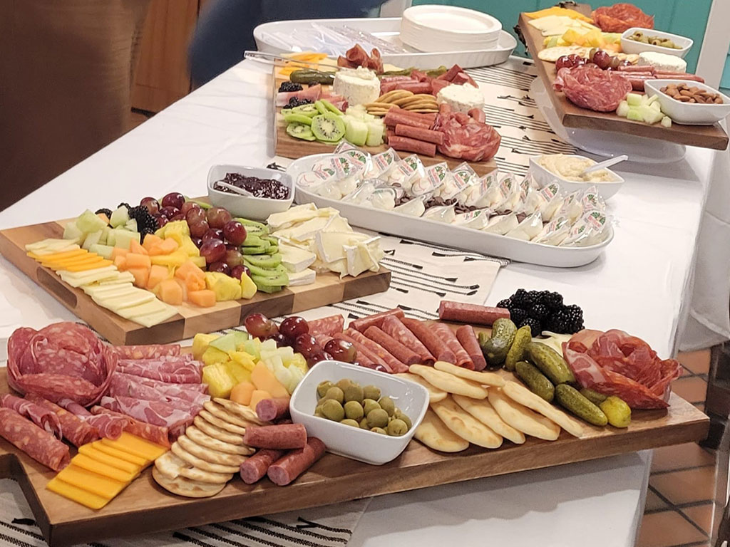 Charcuterie boards with meats, cheeses, olives, hummus and dips