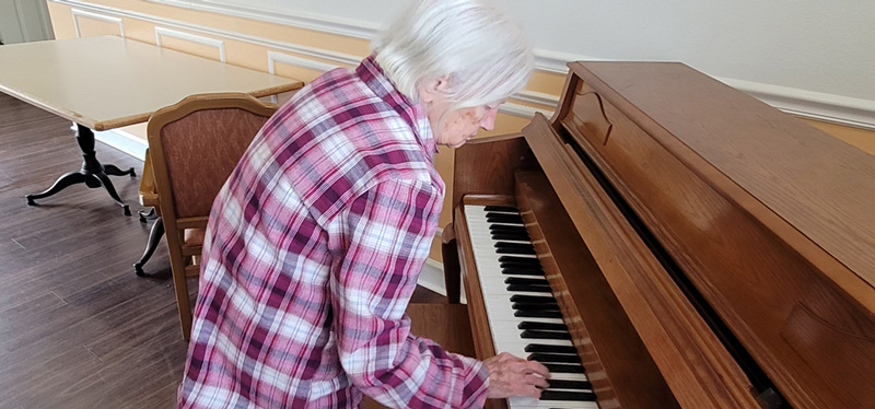 Resident playing the piano at Superior Residence of Brandon