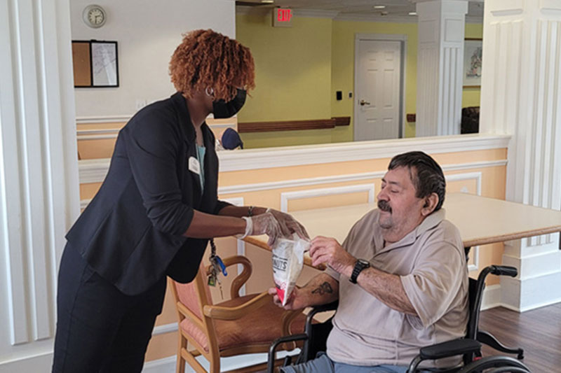 Staff member helping resident with snack at Superior Residences of Brandon